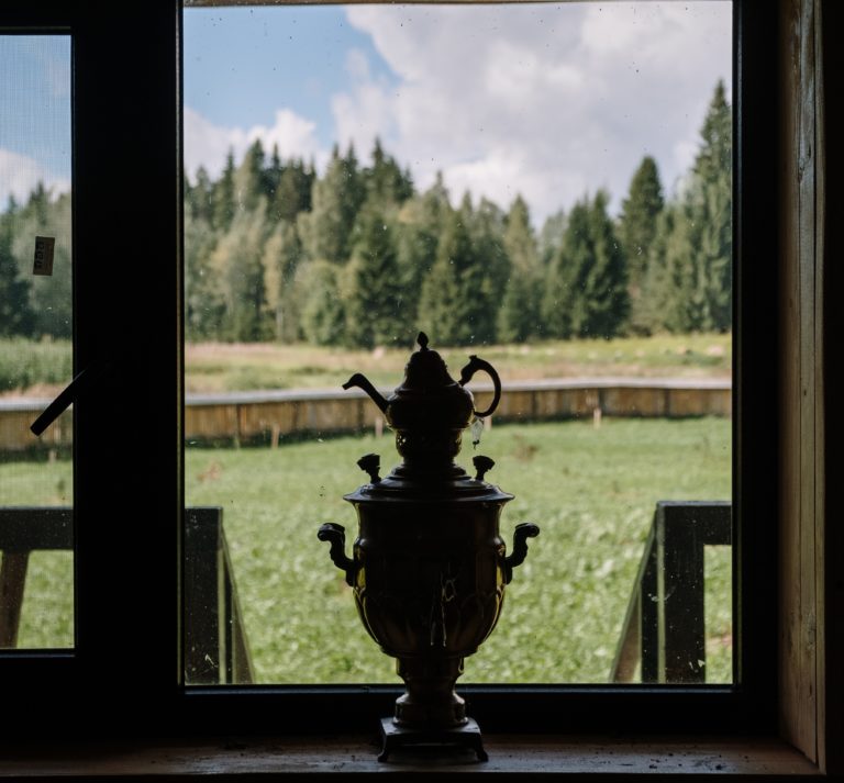 Samowar vor Fenster mit grüner Wiese im Hintergrund
