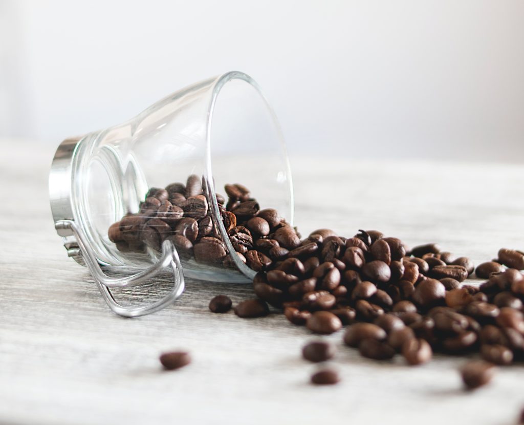 Kaffeebohnen in umgestürzter Espressotasse